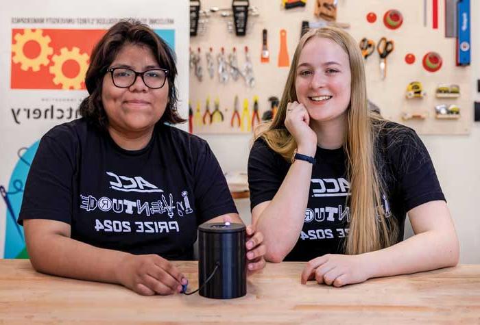Melanie Cotta and Echo Panana photographed in the Hatchery maker space with Hue, a device they invented that identifies colors  for the visually impaired.
